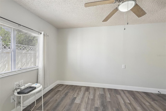 unfurnished room with a textured ceiling, wood finished floors, a ceiling fan, and baseboards