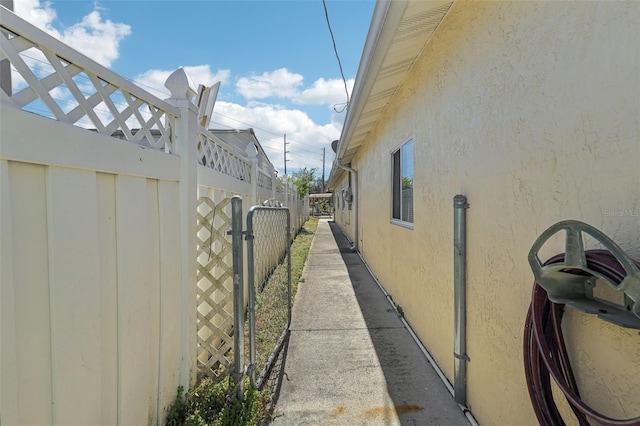 view of side of home with fence and stucco siding