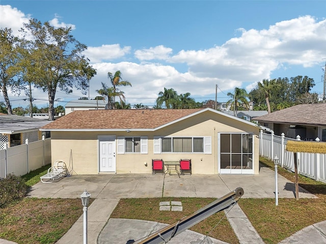 rear view of house featuring fence private yard, stucco siding, and a patio