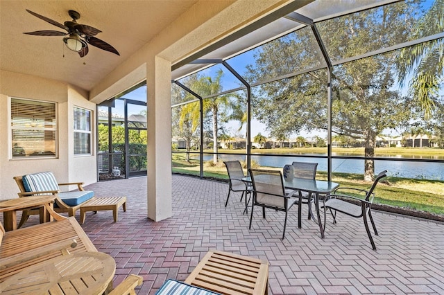 sunroom with a water view and ceiling fan