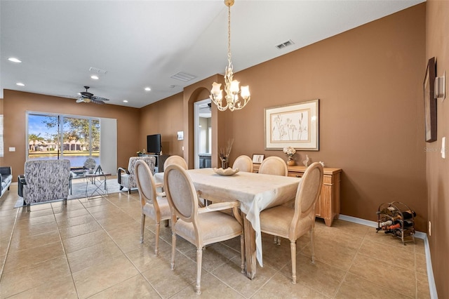 dining area with baseboards, visible vents, arched walkways, and ceiling fan with notable chandelier