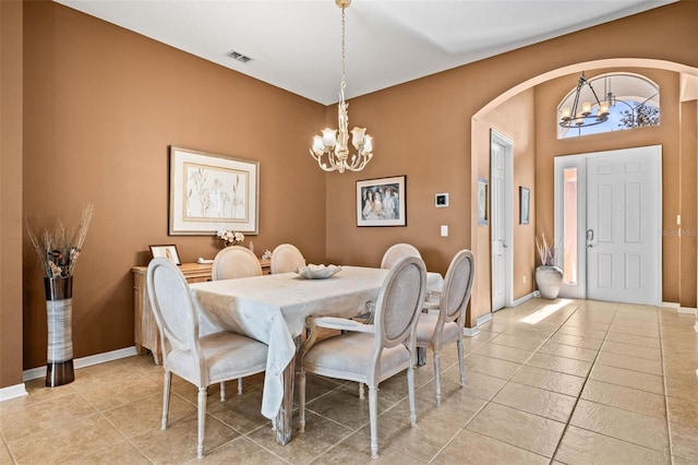 dining room with arched walkways, visible vents, a notable chandelier, and light tile patterned floors