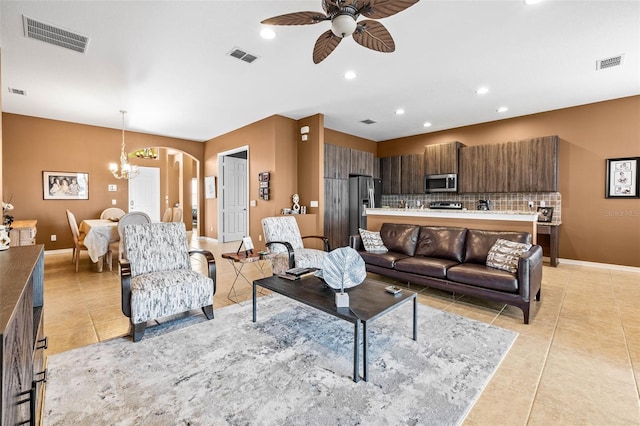 living room featuring light tile patterned floors, visible vents, and arched walkways