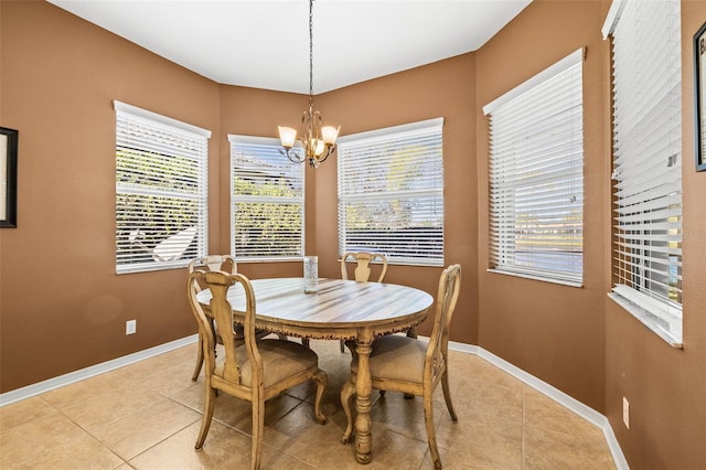 dining room featuring light tile patterned floors, baseboards, and a notable chandelier