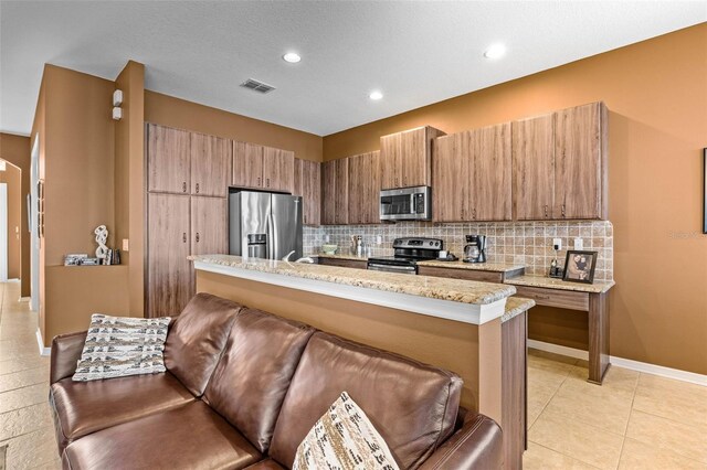 kitchen with tasteful backsplash, baseboards, visible vents, appliances with stainless steel finishes, and light stone counters