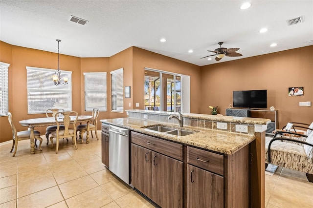 kitchen featuring visible vents, a sink, an island with sink, and dishwasher