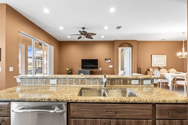 kitchen with arched walkways, open floor plan, a sink, stainless steel dishwasher, and recessed lighting