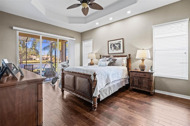 bedroom with ceiling fan, dark wood-style flooring, baseboards, access to outside, and a raised ceiling