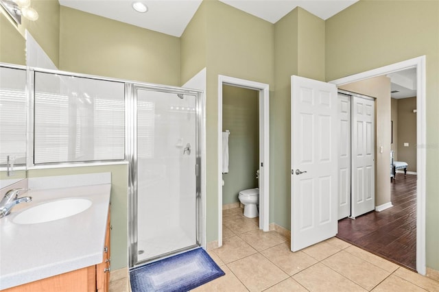 bathroom featuring a stall shower, baseboards, toilet, tile patterned floors, and vanity