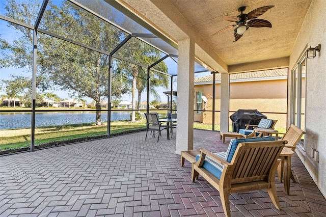 unfurnished sunroom with a water view and ceiling fan