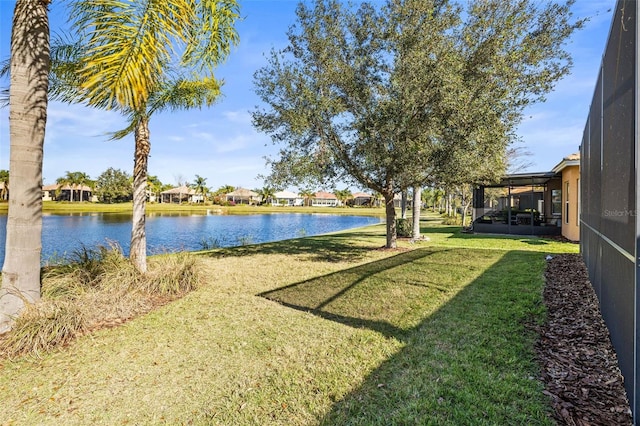 view of yard with a water view and glass enclosure