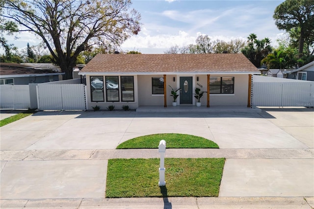 ranch-style house featuring fence and stucco siding