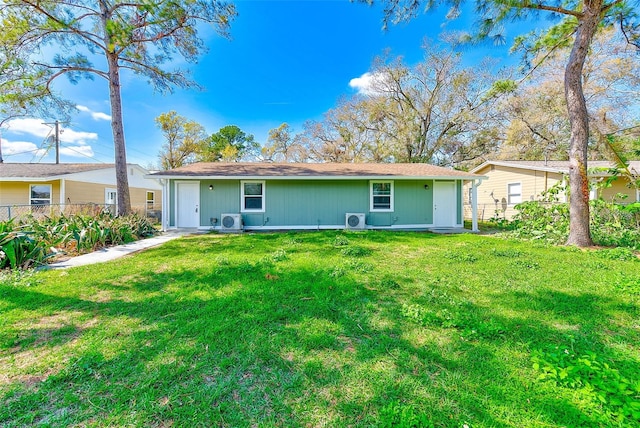 back of property with ac unit, a yard, and fence