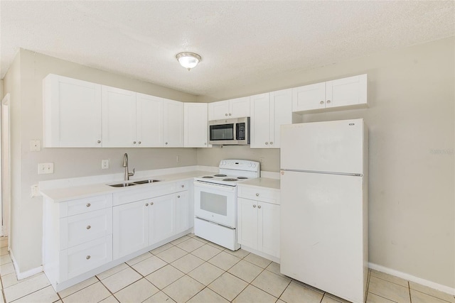 kitchen with light countertops, white appliances, a sink, and white cabinets