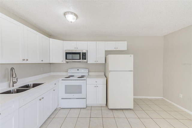 kitchen featuring white appliances, light tile patterned floors, white cabinets, light countertops, and a sink