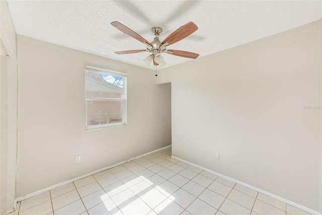 spare room with a ceiling fan, a textured ceiling, baseboards, and light tile patterned floors