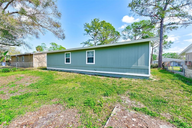 back of house with fence and a yard