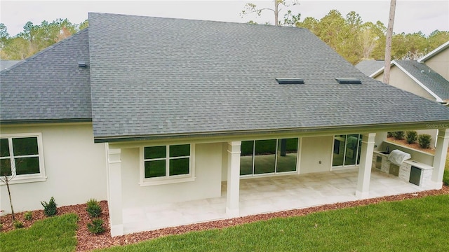 back of property featuring stucco siding, a patio area, and a shingled roof