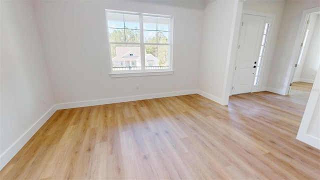 unfurnished room featuring light wood finished floors and baseboards