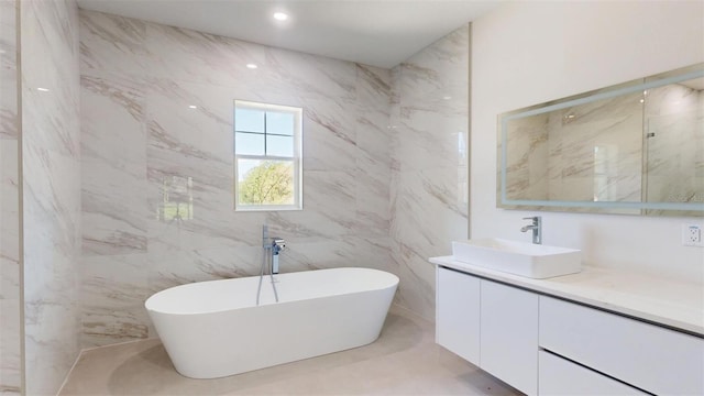 bathroom with vanity, a soaking tub, and recessed lighting