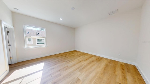 empty room featuring light wood finished floors, visible vents, recessed lighting, and baseboards