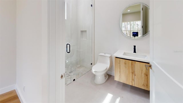 bathroom featuring baseboards, toilet, a stall shower, and vanity