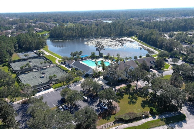 drone / aerial view with a wooded view and a water view