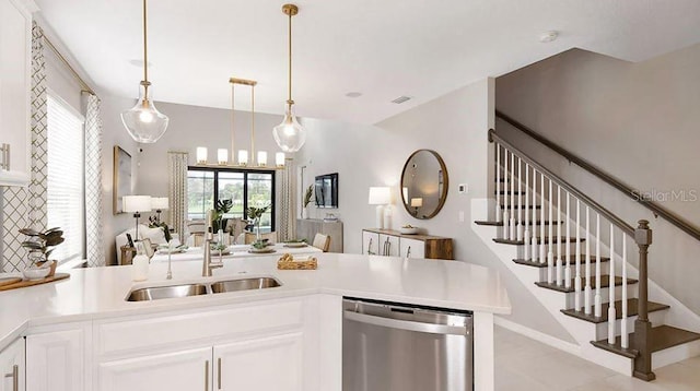 kitchen featuring a sink, white cabinets, light countertops, stainless steel dishwasher, and pendant lighting