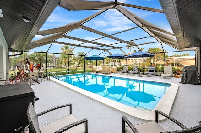 pool with a patio area and glass enclosure