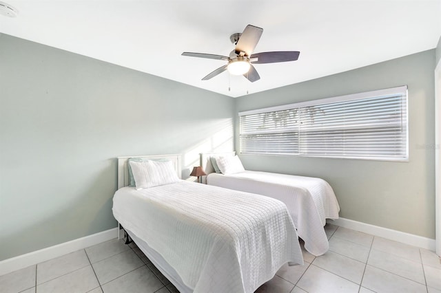 bedroom featuring light tile patterned floors, baseboards, and a ceiling fan