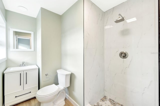 full bath with vanity, a marble finish shower, and toilet