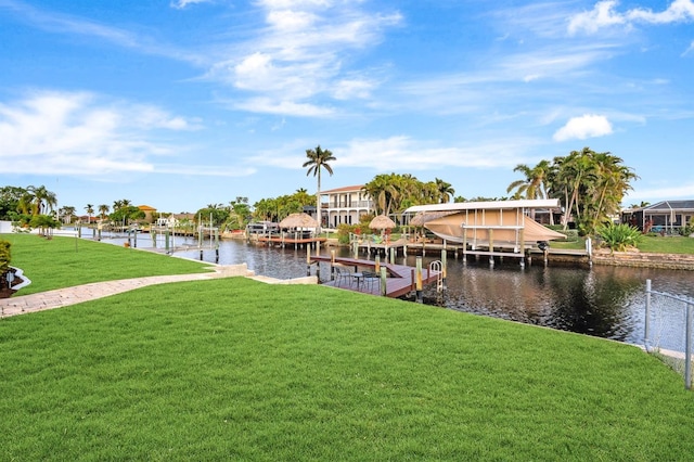 view of dock with a water view and a lawn