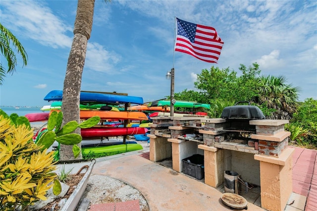 view of patio featuring an outdoor kitchen and a water view