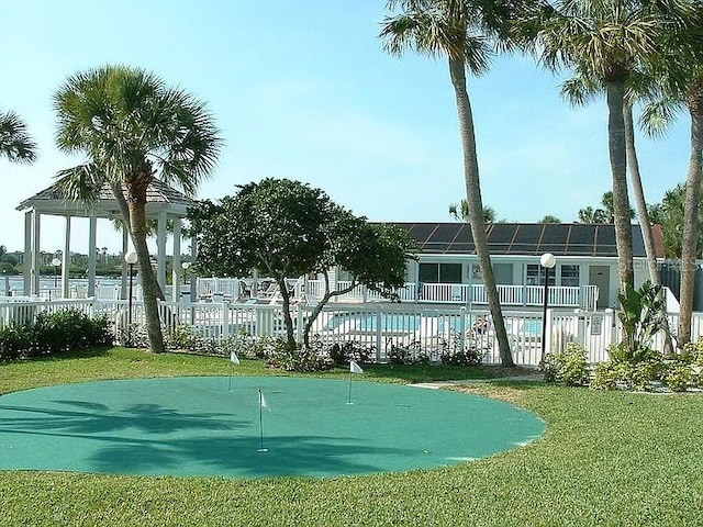 view of property's community with a yard, fence, and a pool