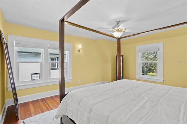 bedroom with a ceiling fan, baseboards, and wood finished floors