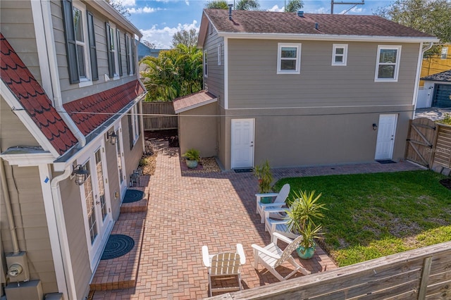 rear view of property featuring a yard, a patio area, a fenced backyard, and stucco siding