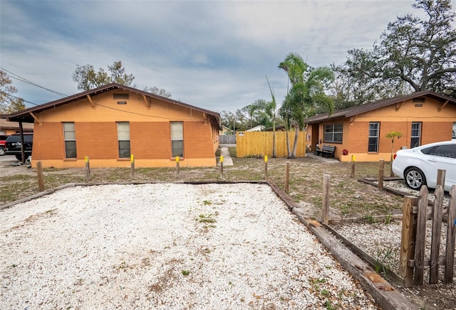 exterior space with fence and brick siding