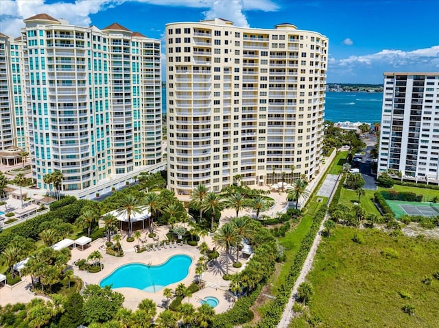 community pool with a patio area and a water view