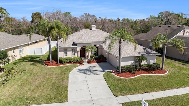 view of front of house with an attached garage, driveway, a front yard, and stucco siding