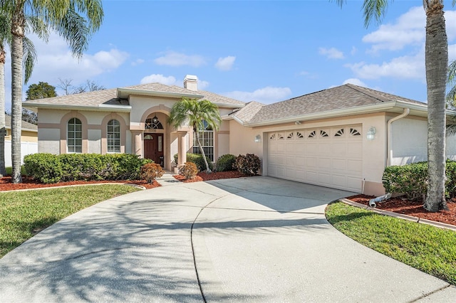 mediterranean / spanish home featuring driveway, a chimney, an attached garage, and stucco siding