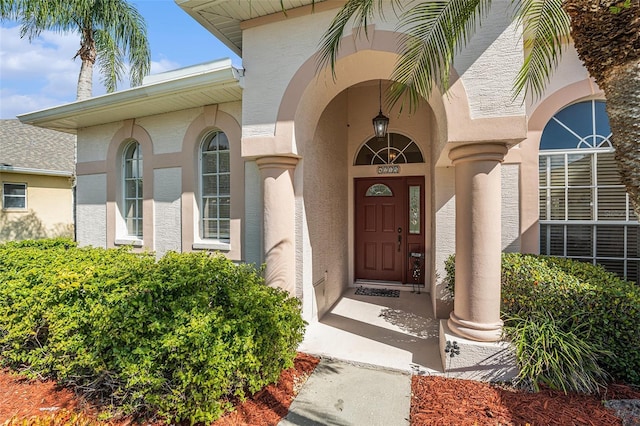 doorway to property featuring stucco siding