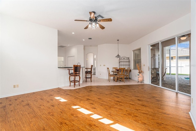 unfurnished living room featuring recessed lighting, visible vents, a ceiling fan, wood finished floors, and baseboards