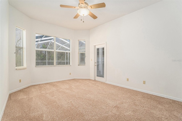 spare room with carpet floors, baseboards, and a ceiling fan