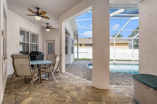 view of patio featuring ceiling fan, a lanai, a fenced in pool, and fence