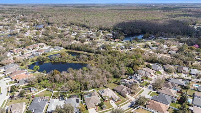 birds eye view of property with a forest view, a water view, and a residential view