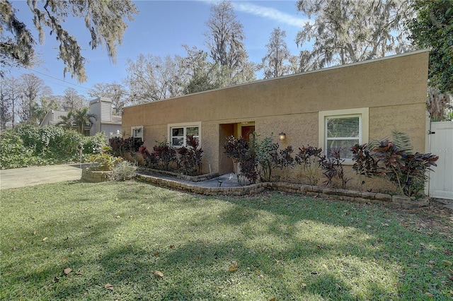 view of front of property featuring a front lawn and stucco siding