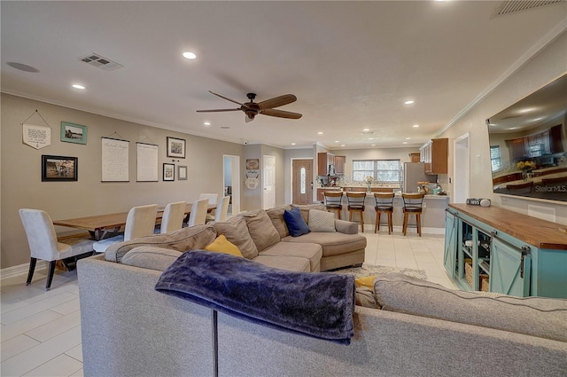 living room with ornamental molding, recessed lighting, visible vents, and light tile patterned flooring