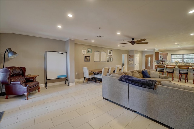 living area with baseboards, recessed lighting, visible vents, and crown molding