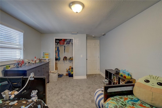carpeted bedroom with a closet, visible vents, a textured ceiling, and baseboards