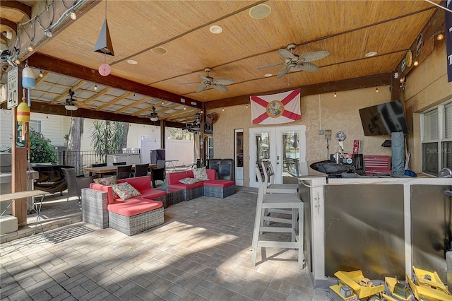 view of patio featuring a ceiling fan, french doors, fence, and an outdoor hangout area